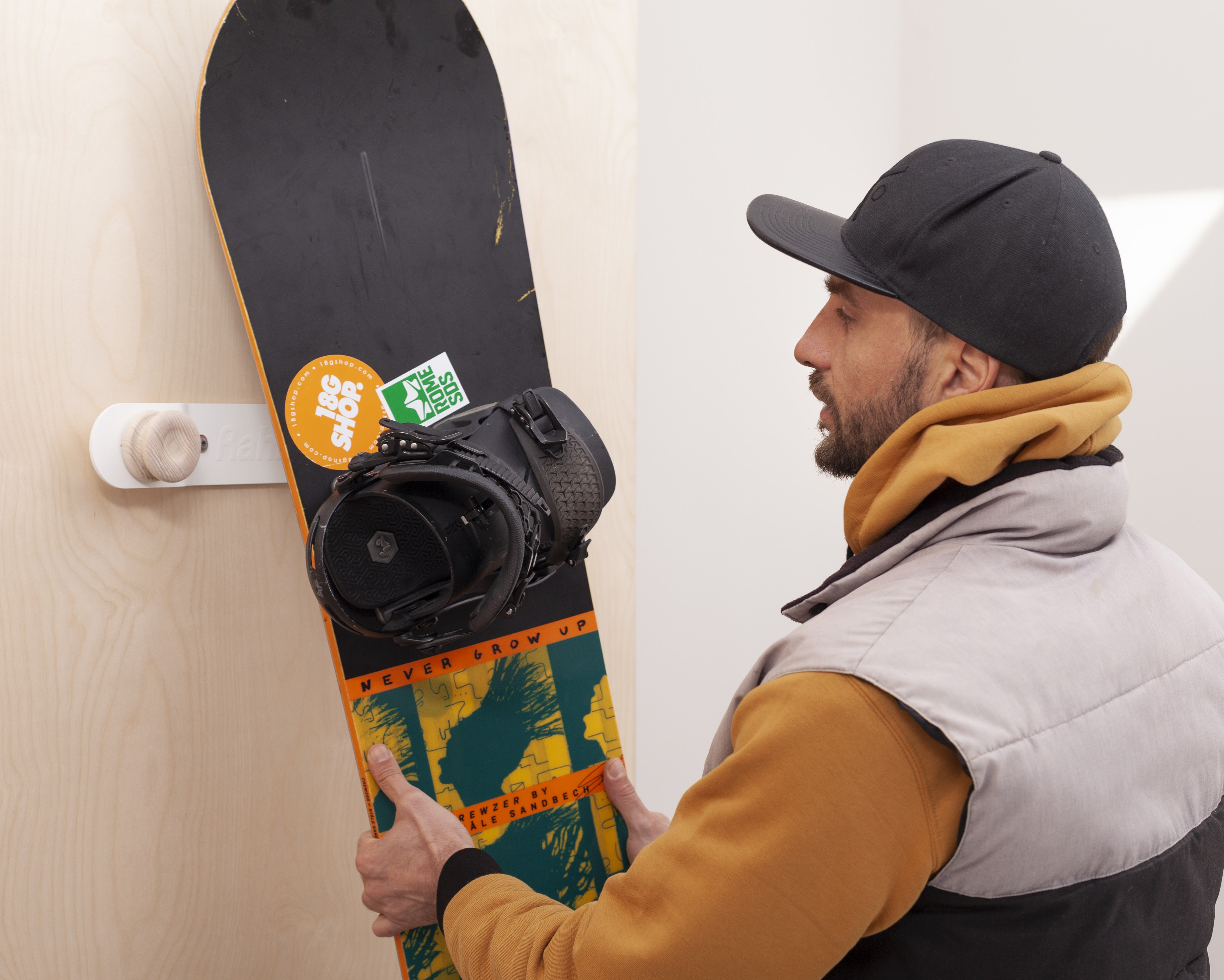 Colourful Rahlle hangers holding a snowboard at home